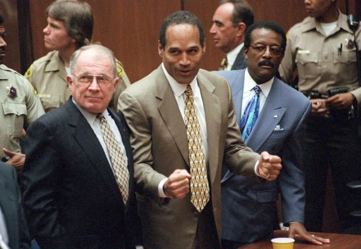 FILE - In this Oct. 3, 1995, file photo, O.J. Simpson reacts as he is found not guilty in the death of his ex-wife Nicole Brown Simpson and her friend Ron Goldman in Los Angeles. Defense attorneys F. Lee Bailey, left, and Johnnie L. Cochran Jr. stand with him. Cochran, Simpson’s flamboyant lead attorney, died of brain cancer in 2005 at 68. His refrain to jurors that “If it doesn’t fit, you must acquit” sought to underscore that the bloody gloves found at Simpson’s home and the crime scene were too small for football legend when he tried them on in court. (Myung J.