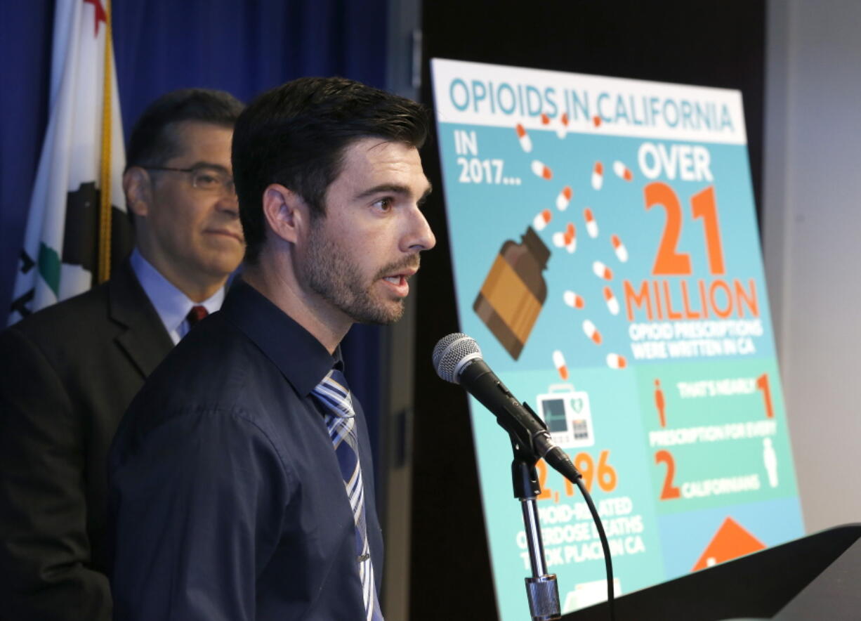 Jordon Basileu, right, flanked by California Attorney General Xavier Becerra, left, discusses how he became addicted to opioid painkillers, during a news conference, Monday, June 3, 2019, in Sacramento, Calif. Becerra announced, Monday that his office has filed a lawsuit against the maker of Oxycontin, Purdue Pharma, and its former president, Dr. Richard Sackler, alleging it falsely promoted the drug as not addictive even as it emerged as among of the most widely abused in the United States.