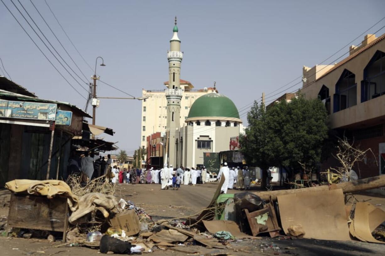 Worshippers gather at a mosque behind a roadblock set up by protesters to stop military vehicles from driving through Wednesday in the Sudanese capital of Khartoum.