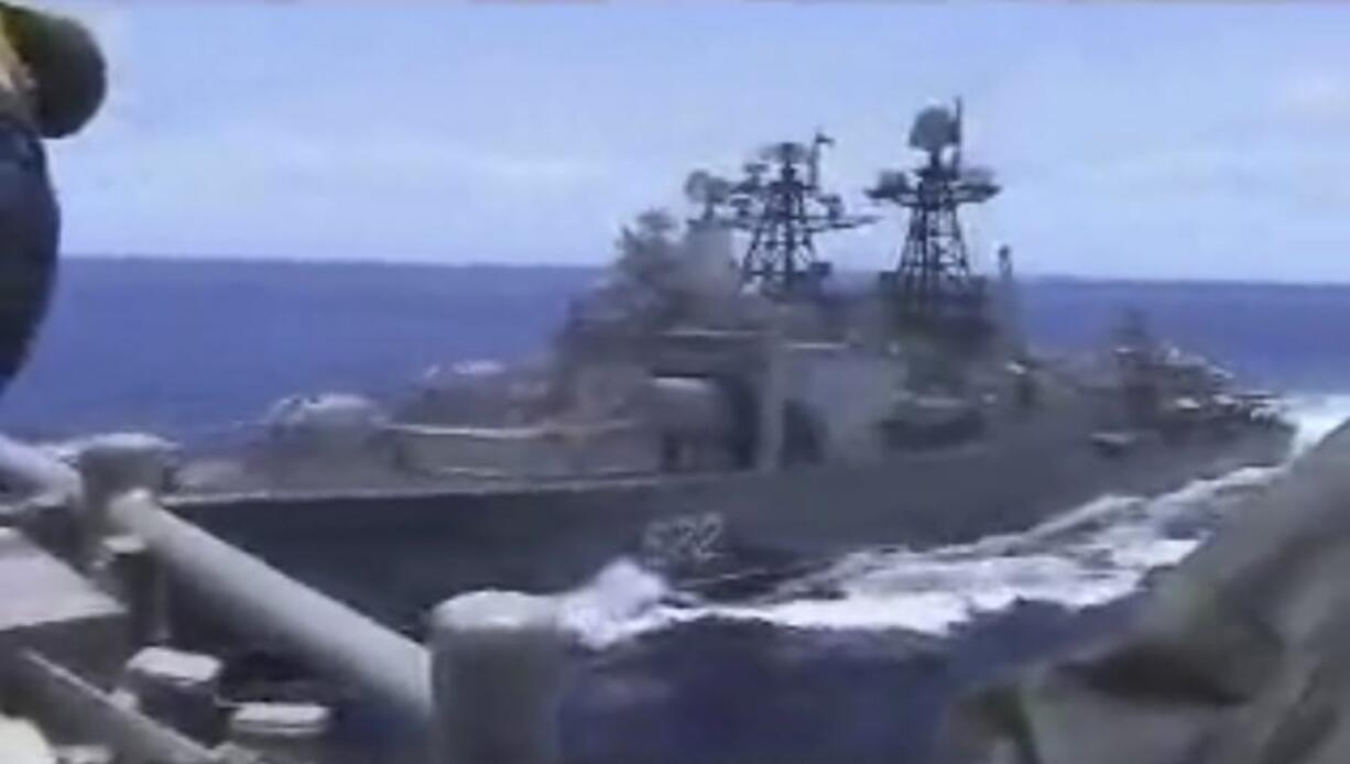 In this image from video, a Russian destroyer, left, sails very close to the USS Chancellorsville, right, while operating Friday in the Philippine Sea. petty officer 1st class christoper j. krucke/U.S.