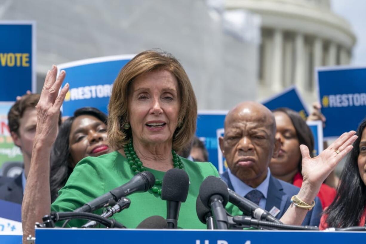 Speaker of the House Nancy Pelosi, D-Calif., flanked by Rep. Terri Sewell, D-Ala., left, and Rep. John Lewis, D-Ga., right, talks to reporters about the need for the Voting Rights Advancement Act of 2019, at the Capitol in Washington, Tuesday, June 25, 2019. (AP Photo/J.