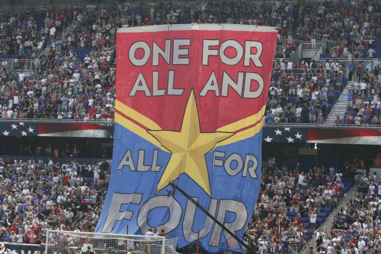 FILE- In this Sunday, May 26, 2019, file photo, fans hold up a banner in support of the United States women’s national team before they compete in the Women’s World Cup during an international friendly soccer match between the United States and Mexico in Harrison, N.J. The World Cup is not just about soccer for many of the players and teams in France. For the defending champion U.S.