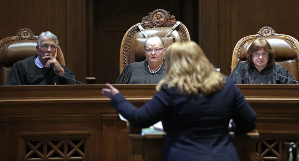 Justice Charles W. Johnson, left, Chief Justice Mary E. Fairhurst and Justice Barbara A. Madsen look on as Michele Earl-Hubbard, attorney for the media coalition, speaks during a hearing before the Washington Supreme Court Tuesday, June 11, 2019, in Olympia, Wash. The court heard oral arguments in the case that will determine whether state lawmakers are subject to the same disclosure rules that apply to other elected officials under the voter-approved Public Records Act. The hearing before the high court was an appeal of a case that was sparked by a September 2017 lawsuit filed by a media coalition, led by The Associated Press.