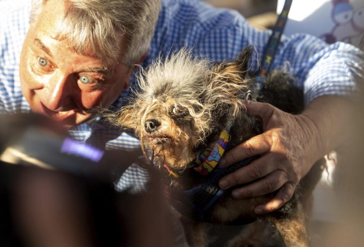 Scamp the Tramp is held after taking top honors in the World’s Ugliest Dog Contest at the Sonoma-Marin Fair in Petaluma, Calif., Friday, June 21, 2019. At left is Kerry Sanders, a reporter who served as one of the judges.