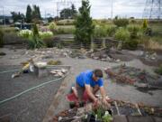 Master gardener Christine Anderson of Vancouver works on the Xeriscaping garden in the Natural Gardens at Pacific Community Park in Vancouver on Tuesday.