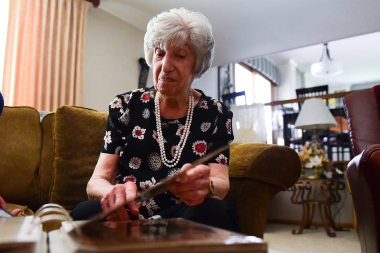 Edith Bonsonto goes through a scrap book with photos of her husband Gerald. Thursday, June 27, 2019, in Orland Park.