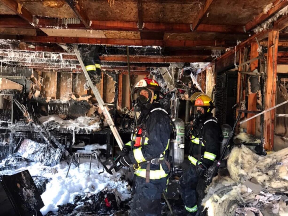 Firefighters inspect a house in Vancouver’s Northwest neighborhood after it was destroyed by fire June 2. The blaze killed a dog.