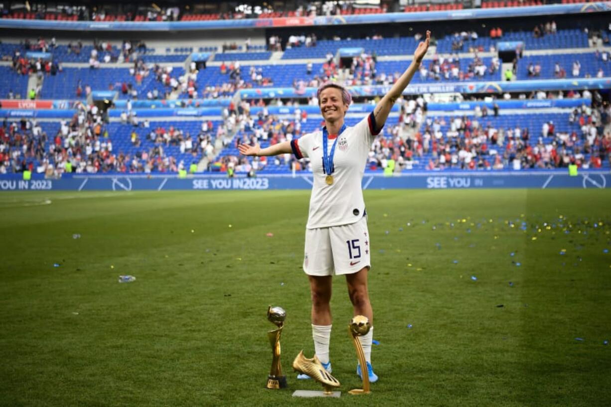 United States’ forward Megan Rapinoe poses with the trophies after the France 2019 Womens World Cup football final match between USA and the Netherlands, on July 7, 2019, at the Lyon Stadium in Lyon, central-eastern France.