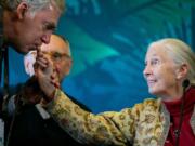 Tracy R. Wolstencroft, president and CEO of the National Geographic Society, kisses the fingernail of Jane Goodall, the famed chimp researcher, before she speaks at a press conference at the Hilton San Diego Bayfront on July 9 in San Diego. Goodall spoke alongside Environmental Systems Research Institute founder Jack Dangermond and biologist E.O. Wilson.