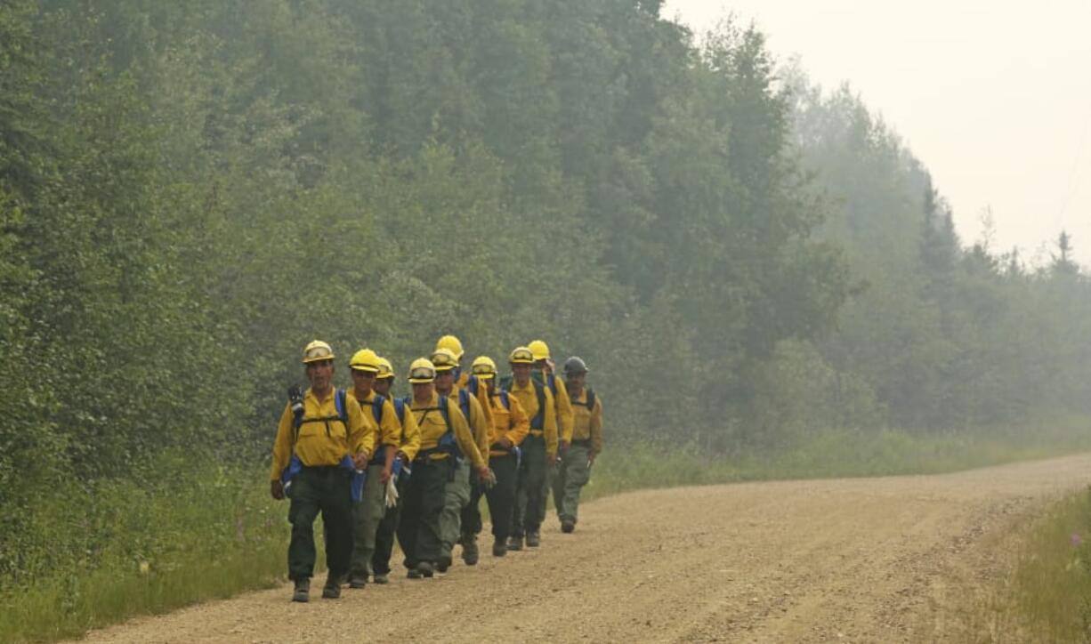 Members of the Southwest Crew 1 walk along a smoky road June 30 near Fairbanks, Alaska, during the fight against the Shovel Creek wildfire.