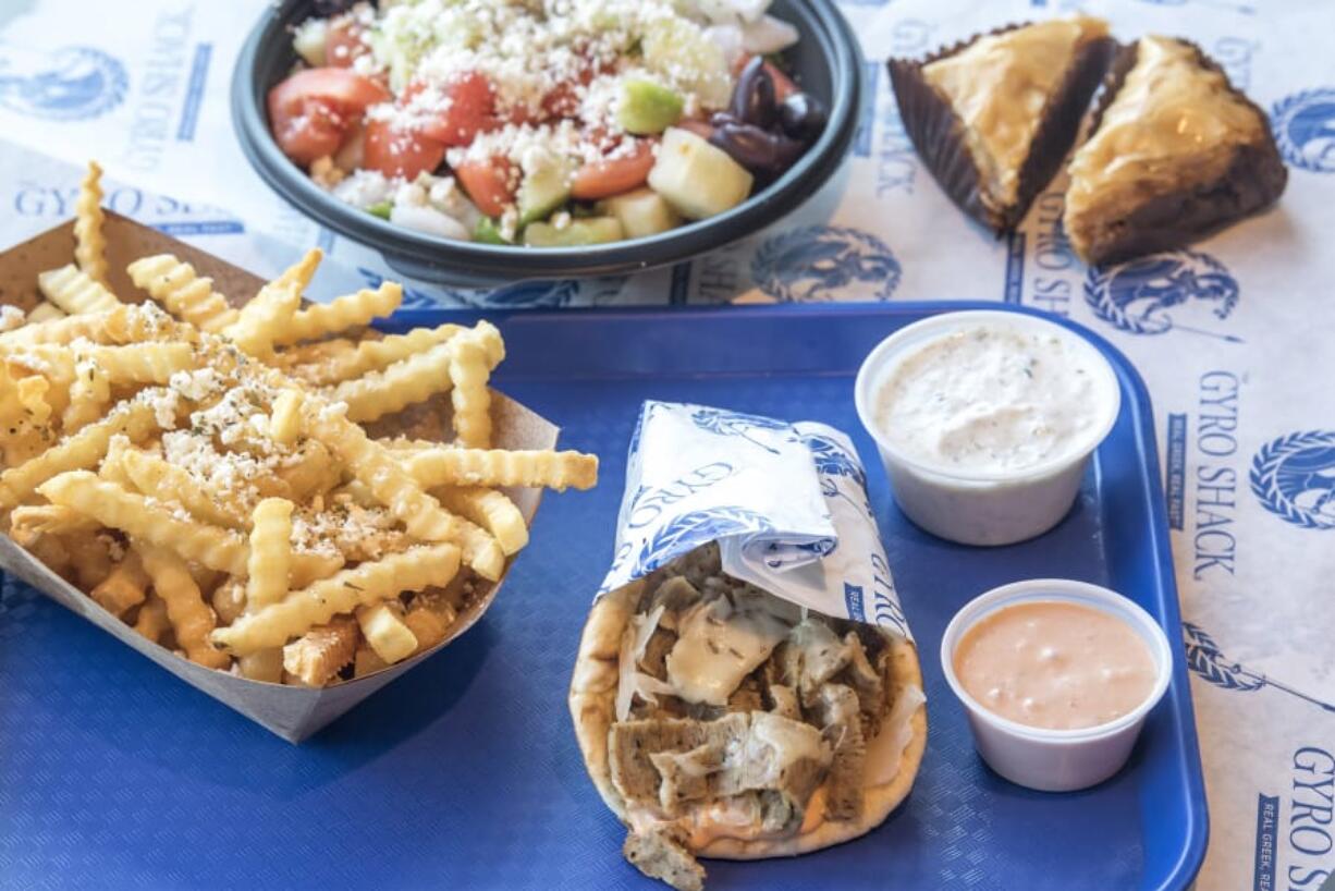 Greek fries, from left, Greek salad, Gyreuben, and a slice of baklava at The Gyro Shack.