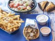 Greek fries, from left, Greek salad, Gyreuben, and a slice of baklava at The Gyro Shack.