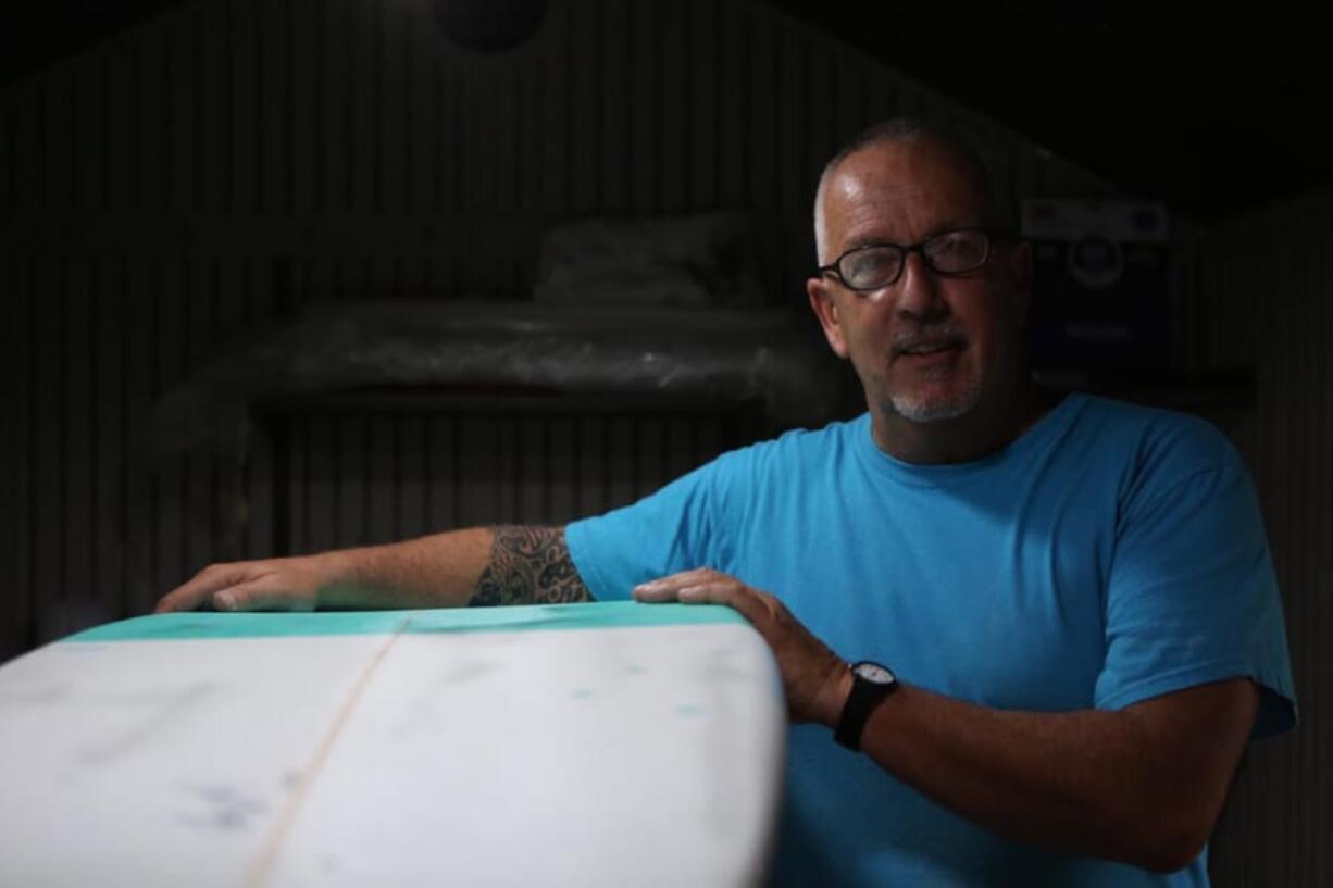 Luke Alvarez, owner of Generic Brand Surfboards, stands with a custom-made surfboard in his shed in Tuckerton, New Jersey on Wednesday, June 11, 2014.