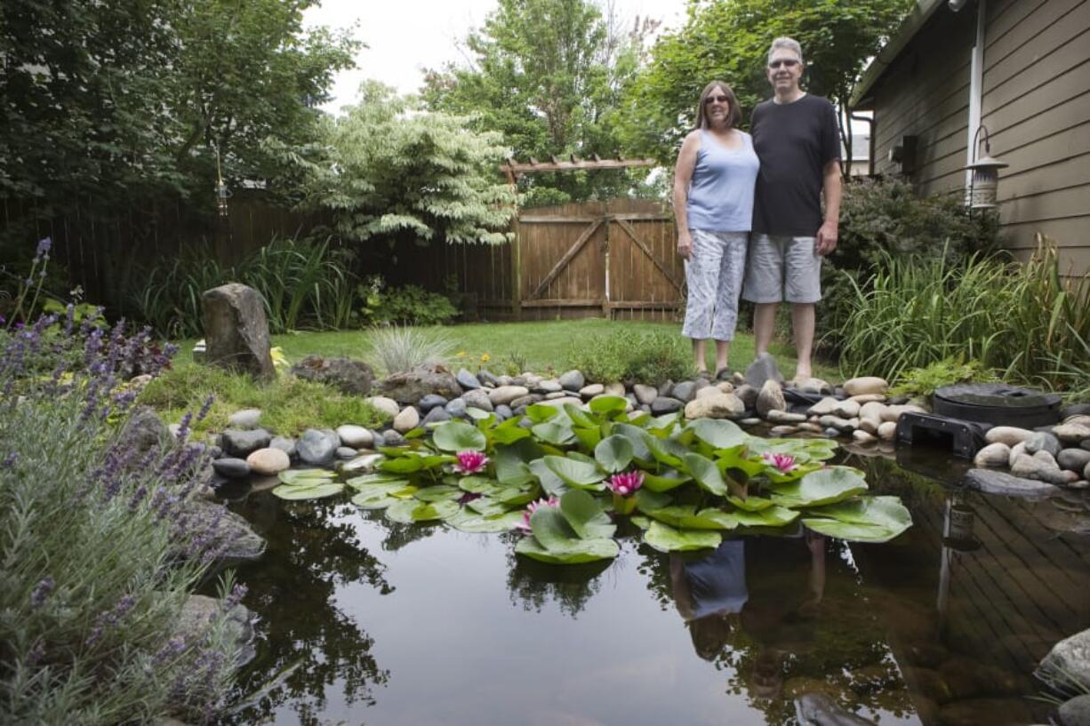 Pam and Marty Almandinger are seen in front of a water feature in their Vancouver garden July 23, 2017, as part of Clark County’s annual self-guided organic garden tour.