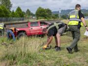 Law enforcement officers partner with members of Burlington Northern Santa Fe Railway to clear debris after a truck was struck by a train at the Whitney Street crossing in Washougal on July 15.