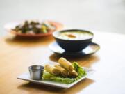 Fried spring rolls, front to back, Yellow Curry with Chicken, and Pra Ram with Beef is seen here at Nom Nom Restaurant and Grill in Vancouver on Tuesday, June 18, 2109.