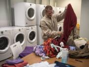 Robert Thompson folds laundry at the Vancouver Navigation Center on June 27. Laundry is one of the most used services. Thompson lives out of his car with his partner, and they come to the day center every day. “They’re doing really good here,” he said.