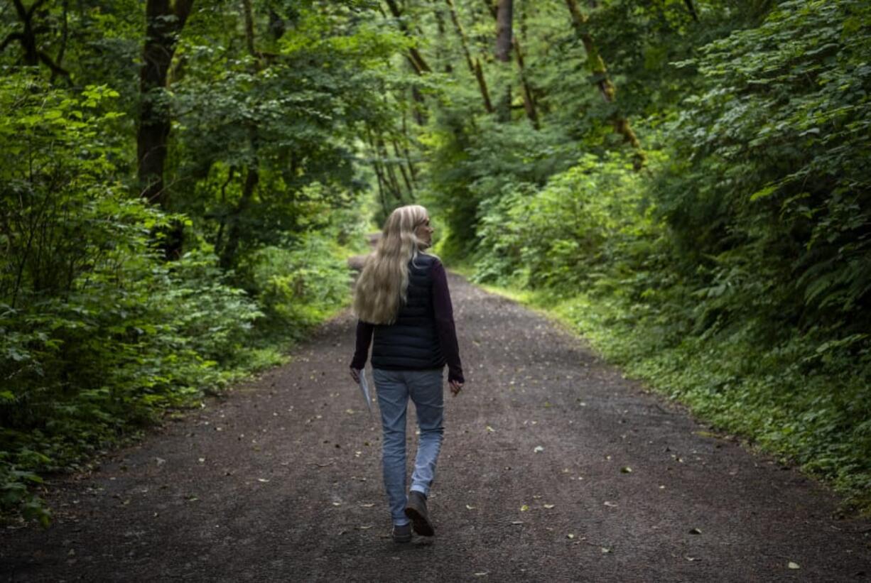 Linda Lorenz of Vancouver looks for the marker signaling the end of the proposed logging area along the Hantwick Trail south of Yacolt last week on June 28. Lorenz owns property just across Northeast Lucia Falls Road from the proposed logging site.