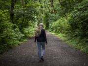 Linda Lorenz of Vancouver looks for the marker signaling the end of the proposed logging area along the Hantwick Trail south of Yacolt last week on June 28. Lorenz owns property just across Northeast Lucia Falls Road from the proposed logging site.