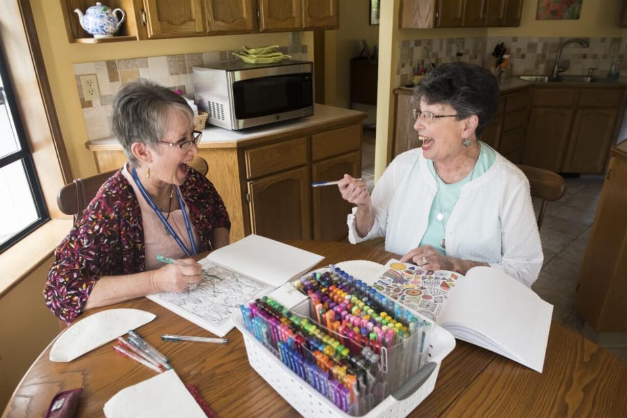 Respite volunteer Rhonda Hurt, left, jokes with hospice patient Marcy Phillips while visiting Phillips’ home in Battle Ground. Hurt visits Phillips for four hours each week to give her husband, Bill, a break, since he is Phillips’ main caretaker.