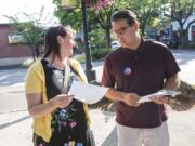 Clark County Council candidate Adrian Cortes and his campaign coordinator, Wendy Cleveland, consult a list of businesses they planned to visit while campaigning during a recent Camas First Friday event.