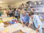 Volunteers Judy Walter, left, and Shirley Brandenburg with Babies in Need build layettes at All Saints Episcopal Church in Hazel Dell. Walter said she’s been volunteering with the group since the early 2000s.