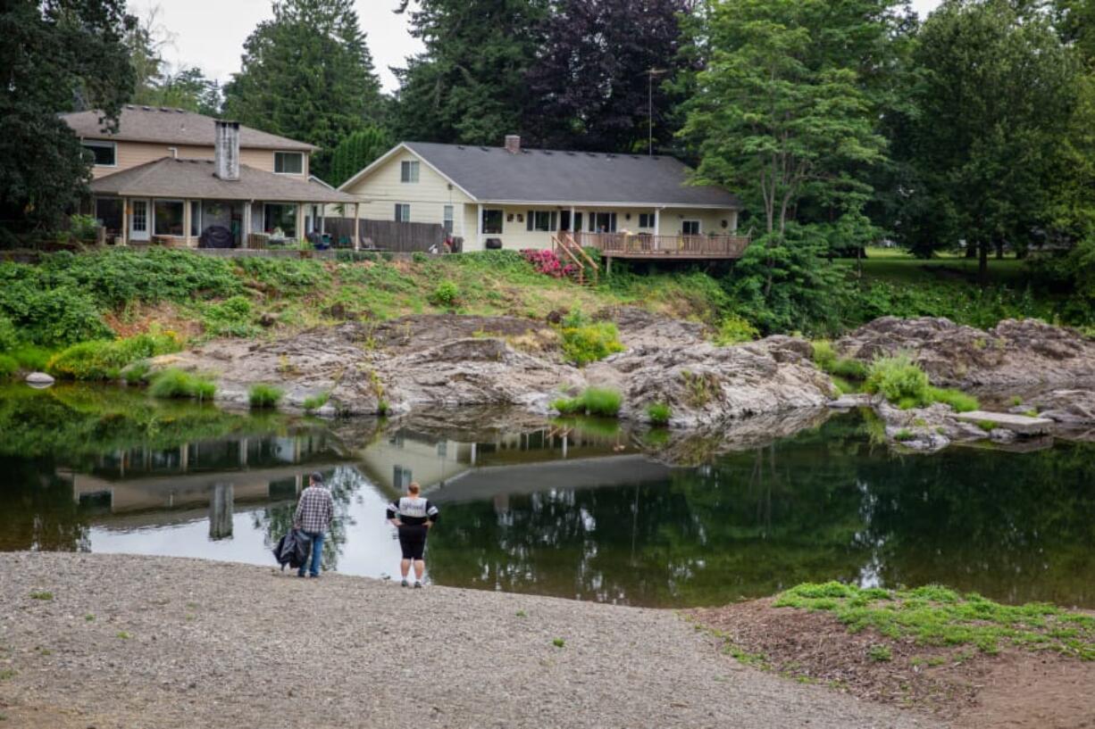 Visitors look out at the water Saturday afternoon at Sandy Swimming Hole Park in Washougal.