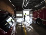 Firefighter Paramedic Lyle Mann hoses down the vehicle bay at Vancouver Fire Station 2.