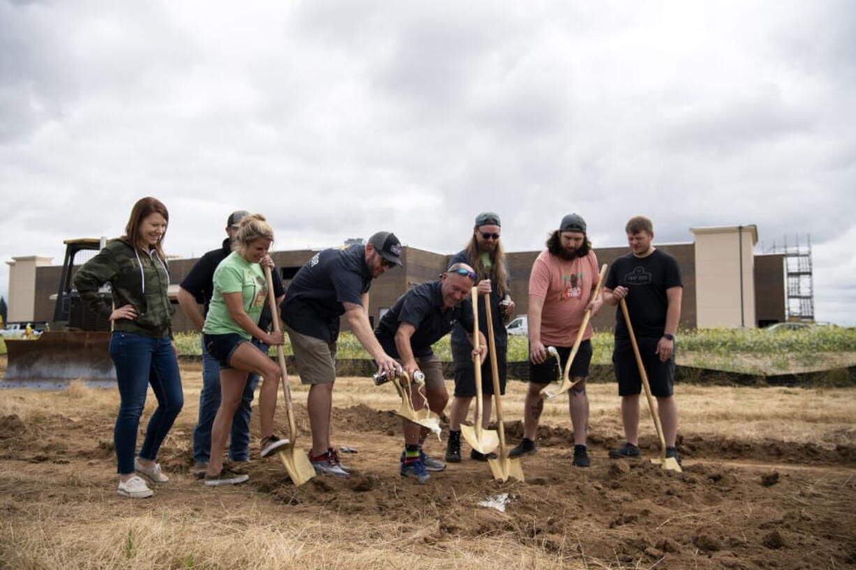 The Trap Door team pours beer out onto the golden shovels during the groundbreaking ceremony at the site of Pioneer Village in Ridgefield. Trap Door was the first tenant to sign a lease at the mixed-use development, which will also include about 300 apartments.