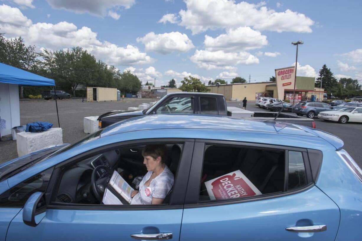 Kathy Decker, a candidate for Vancouver Public Schools Board of Directors Position 4, studies her campaign material in the parking lot of Grocery Outlet before campaigning at the Fourth Plain Community Market. Decker resigned her position as a kindergarten teacher at Peter S. Ogden Elementary School to run for school board, saying her experience as a teacher will help her frame policy and direction for Clark County’s second-largest school district. She’s one of several other teachers running for political office this campaign cycle.