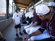 Aidan Deeney of Vancouver, 11, chats with the Raptors players before the game against the Cowlitz Black Bears at the Ridgefield Outdoor Recreation Complex on Friday night, July 12, 2019. Two local kids get to help out the team each game by retrieving balls and bats from the field.