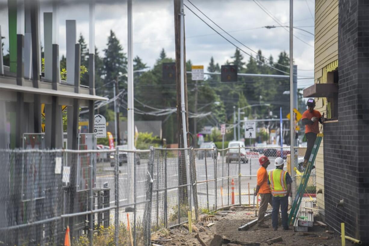 A construction crew works on a new Starbucks location Tuesday on Fourth Plain Boulevard. With investments pouring into central Vancouver, the city council is worried that the rising standard of living could end up pricing out the very residents the projects are meant to benefit.