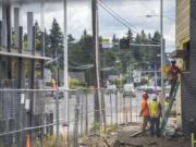 A construction crew works on a new Starbucks location Tuesday on Fourth Plain Boulevard. With investments pouring into central Vancouver, the city council is worried that the rising standard of living could end up pricing out the very residents the projects are meant to benefit.