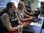 Deputy Melissa Sager and her fellow deputies meet for an afternoon debriefing at the Clark County Sheriff’s West Precinct in Ridgefield on July 18.