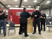 Clark County Fire District 6 Firefighter Tony Lothspeich prepares to receive an award from Board of Fire Commissioners Chair Casey Collins on Tuesday at Station 61 in Hazel Dell.