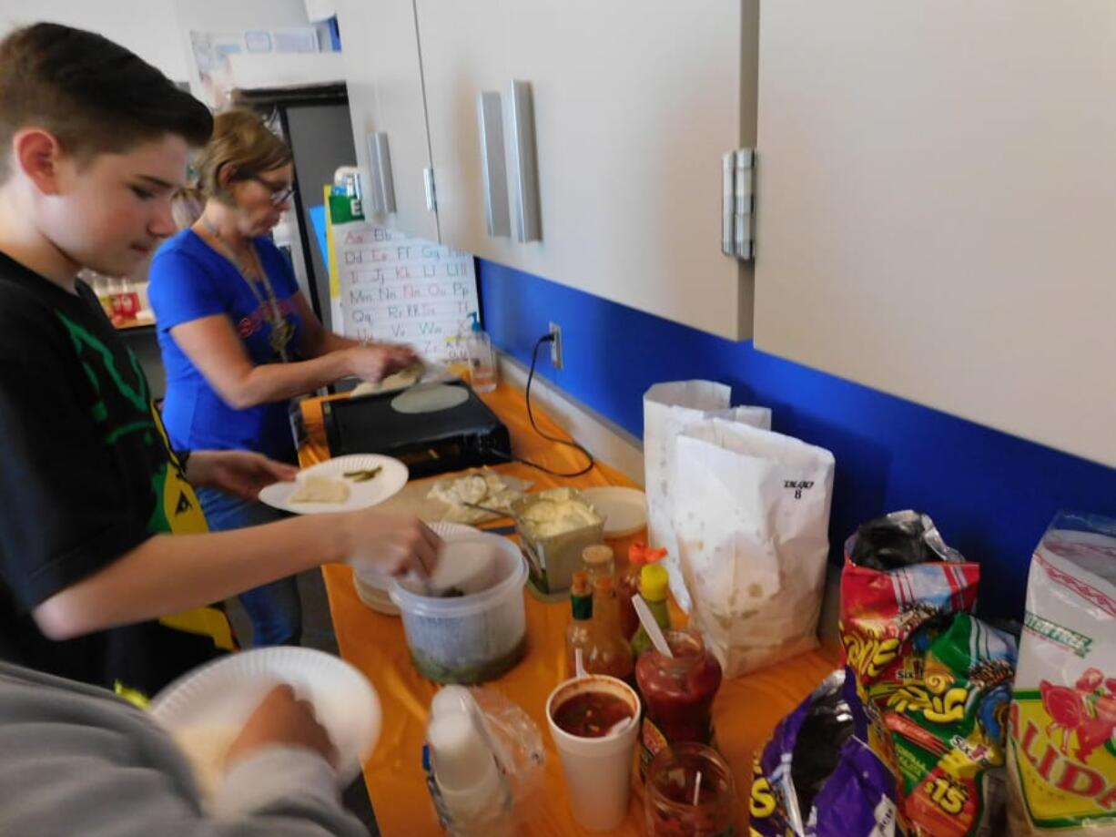 Ridgefield: View Ridge Middle School Spanish teacher Jennifer Zora heats tortillas for her students during the class celebration on Mexican heritage.