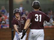 Raptors Justin Boyd (2) and Michael Hicks (31) high five after Boyd makes a run during Friday night's game against the Pickles at the Ridgefield Outdoor Recreation Complex on July 19, 2019. The Raptors won 5-2.