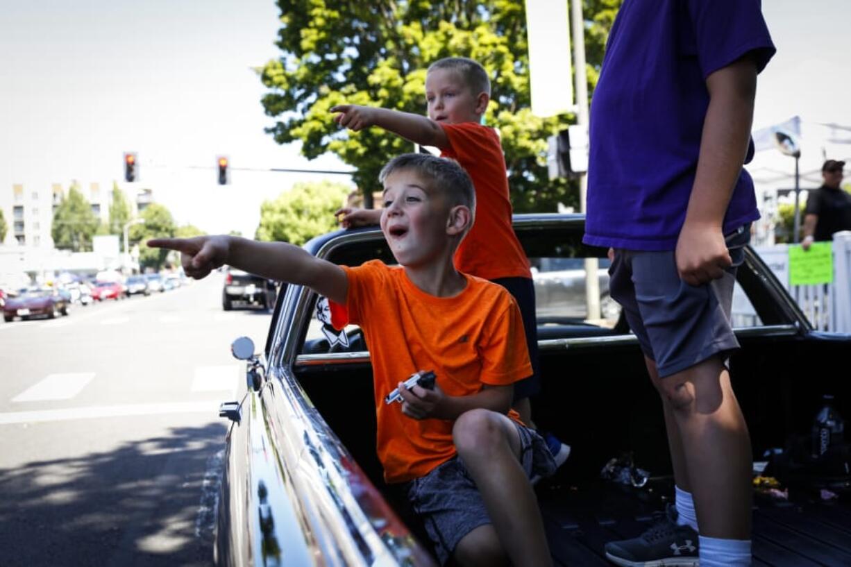 Six-year-old Eldon Girdini, from left, Eli Strom, 4, and Arlo Girdini, 8, cheer in awe at the vintage cars driving down Main Street during the Cruise the Couve event in Vancouver on Saturday.