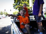 Six-year-old Eldon Girdini, from left, Eli Strom, 4, and Arlo Girdini, 8, cheer in awe at the vintage cars driving down Main Street during the Cruise the Couve event in Vancouver on Saturday.