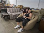 Marsha Barley, 69, embraces her son, Lance, 43, while shopping for furniture at NW Furniture Bank on Friday. The Barleys were living in their van until they recently got housing through the Vancouver Navigation Center. People can shop for all the furniture they need for $75 at NW Furniture Bank.