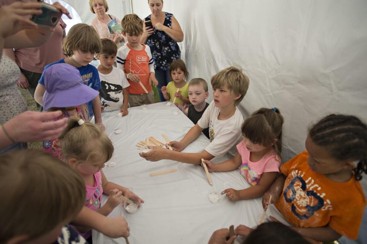 Kids use their imagination to create craters in an “alien surface” before they start working on building rovers outside La Center Community Library on Monday afternoon.