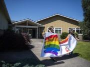 Congregant Kristin Wade, left, and Pastor Susan Boegli, right, carry new welcome banners to the front of the Battle Ground Community United Methodist Church on Northeast 199th Street. Boegli said the church added a rainbow to its sign two years ago to show that all are welcome regardless of sexual orientation. It has been repeatedly vandalized and, as a result, reprinted.