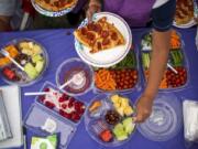 Kids line up for a pizza lunch Wednesday during Vancouver Parks and Recreation’s Summer Playgrounds Program at Evergreen Park in Vancouver.