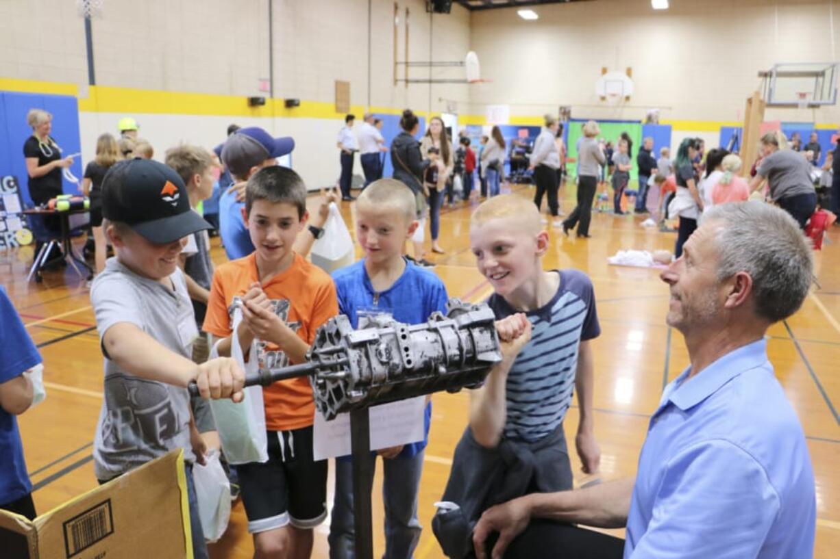 BATTLE GROUND: Fourth-graders try their hand at the Automotive Careers booth at the first-ever Career Exploration Fair, held by Battle Ground Public Schools last month. Students from seven primary schools in the district attended.