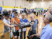 BATTLE GROUND: Fourth-graders try their hand at the Automotive Careers booth at the first-ever Career Exploration Fair, held by Battle Ground Public Schools last month. Students from seven primary schools in the district attended.