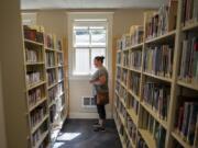 Carey Hanson of Woodland searches for a few books to read at the Woodland Community Library. “I love this library. I’m always here,” Hanson said from a cramped aisle of the library in 2019.