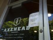 A sign in the window at Axehead directs customers to call the owners for service. The store became embroiled in a social media backlash last week following a post that featured and anti-gay slur.