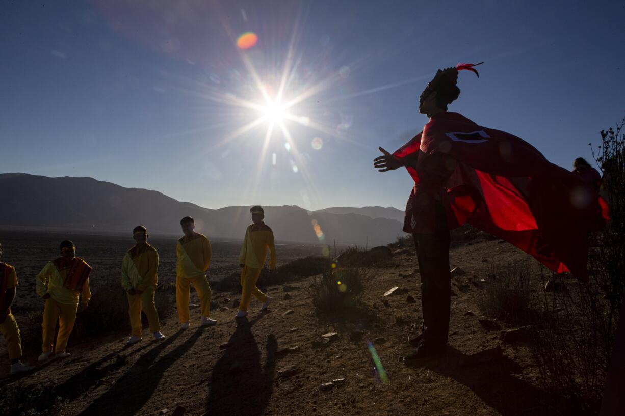 A youth dressed as a shaman arrives to take part in a photo session before Tuesday's total solar eclipse, in La Higuera, Chile, Monday, July 1, 2019. Tourists and scientists will gather in northern Chile, one of the best places in the world to watch the next the eclipse that will plunge parts of South America into darkness.