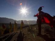 A youth dressed as a shaman arrives to take part in a photo session before Tuesday's total solar eclipse, in La Higuera, Chile, Monday, July 1, 2019. Tourists and scientists will gather in northern Chile, one of the best places in the world to watch the next the eclipse that will plunge parts of South America into darkness.