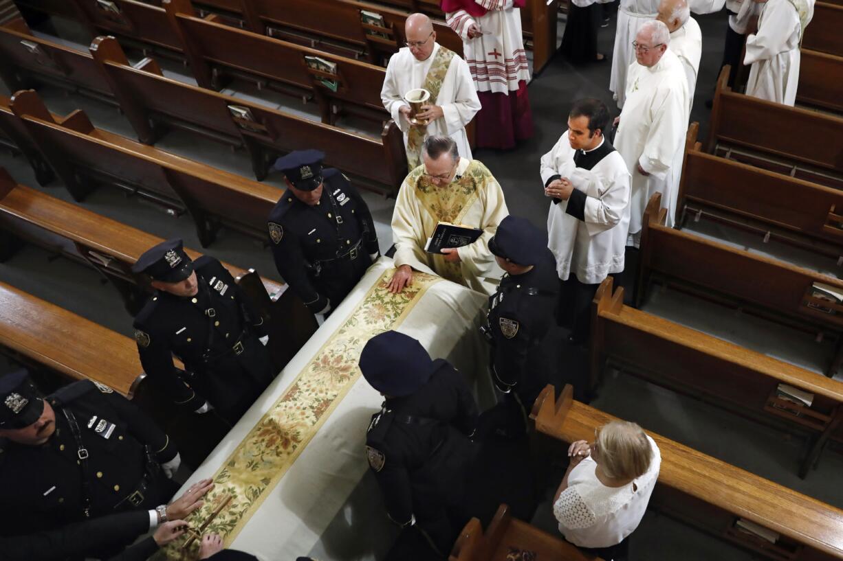 Rev. John P. Harrington blesses the casket during the funeral ceremony for Detective Luis Alvarez, at Immaculate Conception Church, in the Queens borough of New York, Wednesday, July 3, 2019. Alvarez, 53, who died after a three-year battle with colorectal cancer, fought until his final days for the extension of the Sept. 11 Victim Compensation Fund.